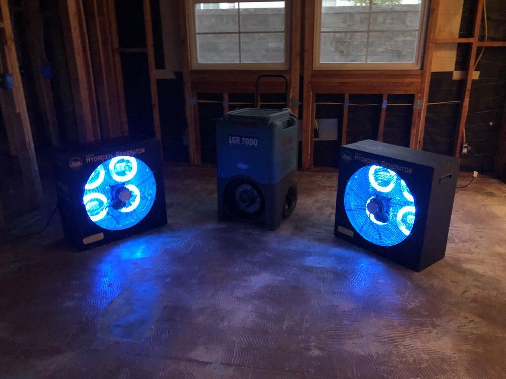 HEPA air scrubber running in a gutted room during restoration