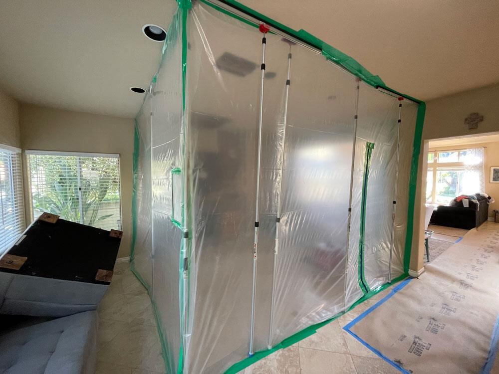 Plastic containment barrier sealing off a work area to stop mold spores and dust from spreading