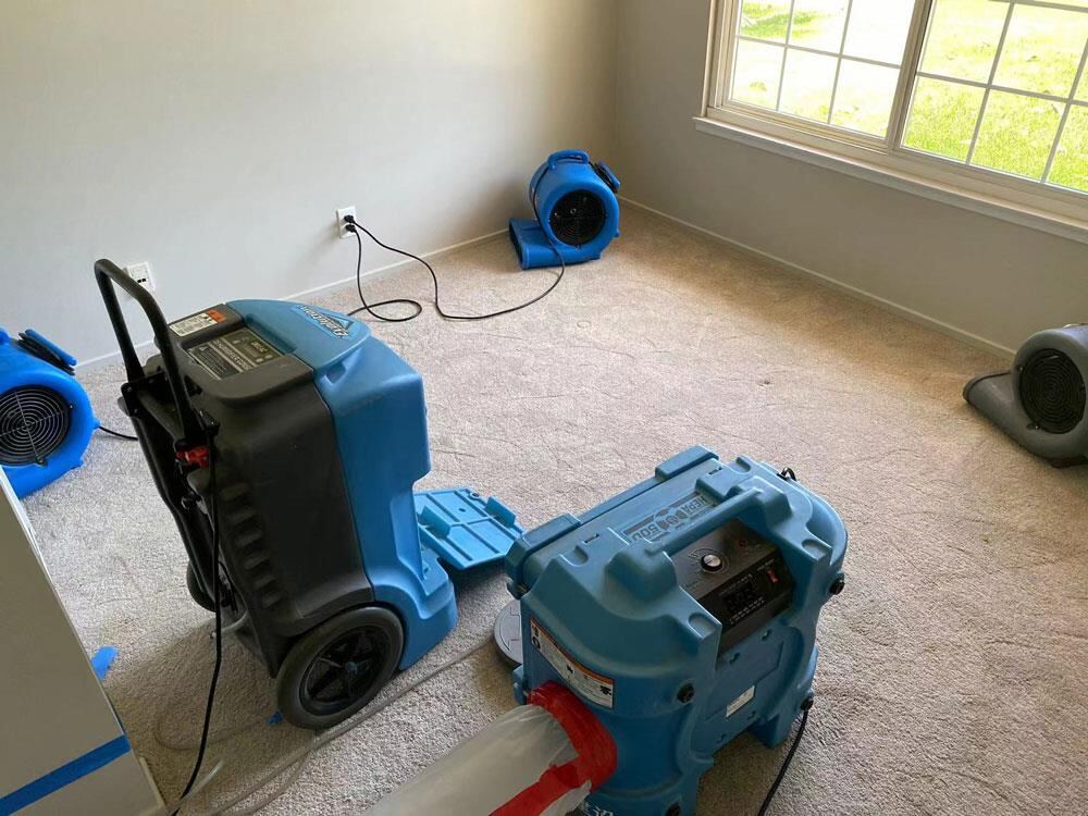 Bedroom carpet water damage dried with a dehumidifier and several air movers